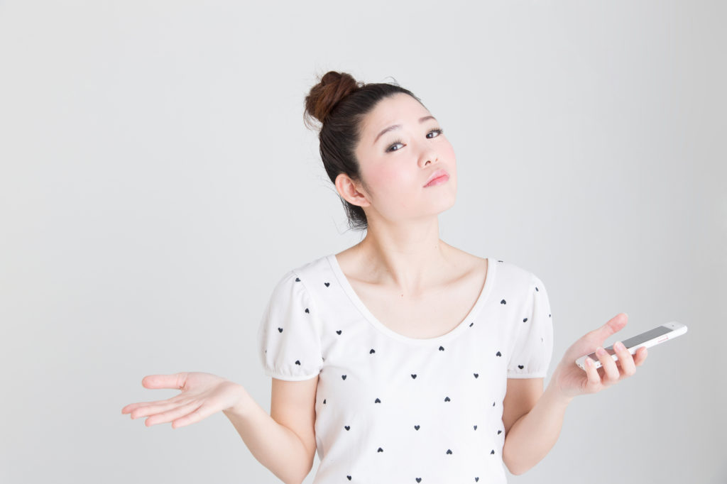 スマホを片手に問いかける日本人女性